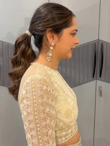 A simple and chic ponytail with a decorative tie, perfect for a bridesmaid or a wedding guest.