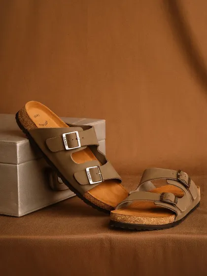 A clean, simple product shot of two-strap sandals against a neutral brown background. This minimalist setup is perfect for e-commerce, focusing entirely on the product's design and color.