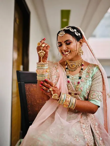 A lovely candid shot of the bride admiring her bangles. The soft glam makeup ensures she looks perfect from every angle.