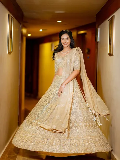 A full-length shot of the bride twirling in her golden lehenga. The movement of the skirt and her bright smile create a photo that is both dynamic and joyful.