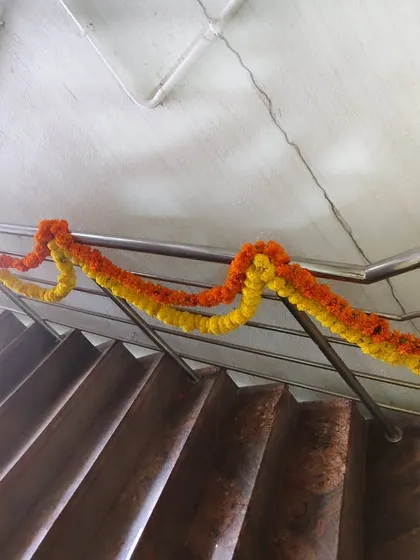 Another example of simple marigold garlands on a staircase railing.