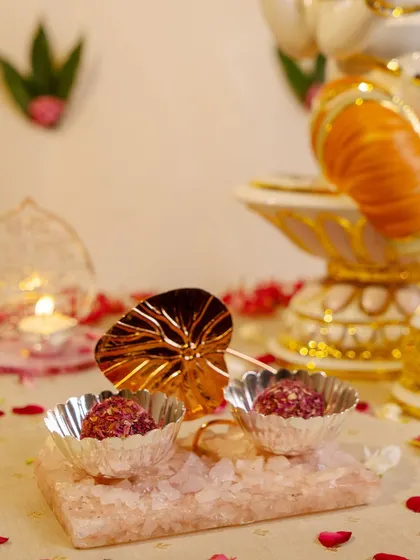A festive offering to Lord Ganesha. This scene captures the spirit of celebration with modaks served in silver bowls on a rose quartz tray, creating a beautiful and devotional display.