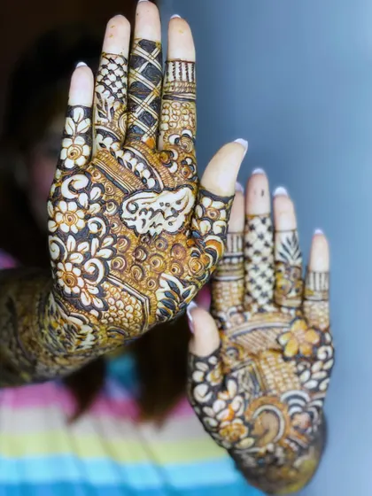 A close-up of the palms, featuring the name "Adil" beautifully written inside a floral motif.
