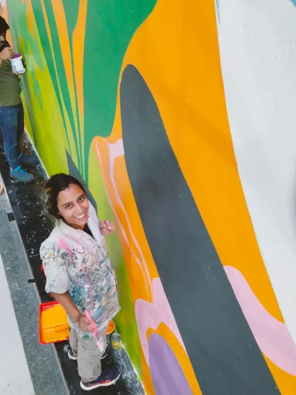 A happy moment with my team member during the Hyderabad mural project. The camaraderie is one of the best parts of these big jobs.