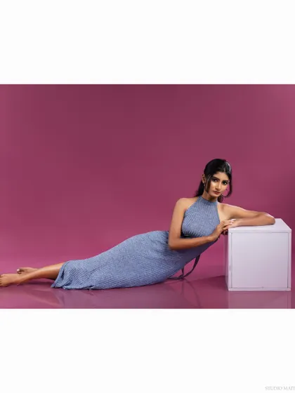 A wide-angle shot of the model reclining, showing the full length of the dress.