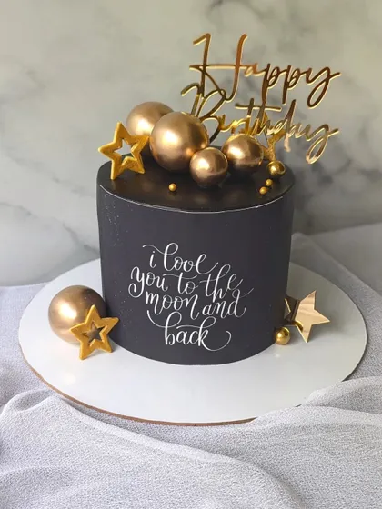 A simple yet powerful design for a 50th birthday. This black cake features elegant calligraphy saying "I love you to the moon and back," accented with gold stars and spheres.