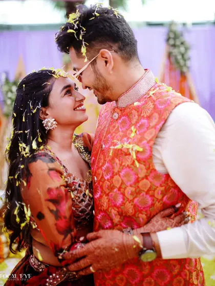 A candid moment of connection during a Haldi ceremony, with the couple looking at each other with love and amusement.