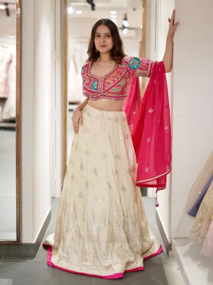 This lehenga might just leave you awestruck. The off-white skirt with silver work is paired with a colorful, intricately embroidered blouse for a pop of fun.