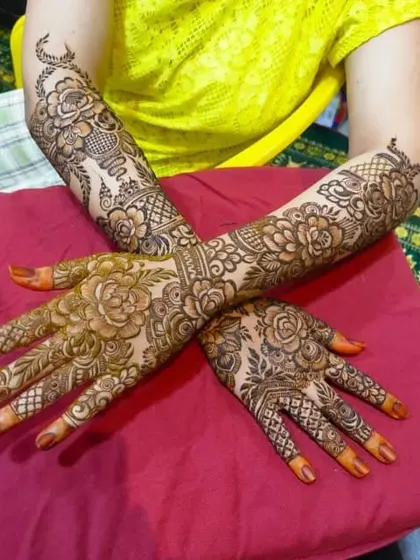 A beautiful example of full bridal henna, where both hands are adorned with matching floral and jaal patterns. This symmetry is key for stunning photographs of your hands together.