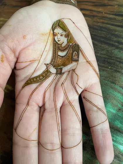 The bride's portrait with the lehenga skirt sketched in, showing how the design extends to cover the fingers.