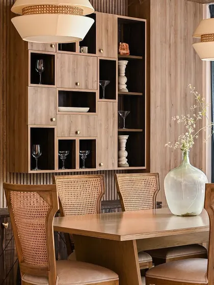 A close-up of the dining area, highlighting the custom-built display unit and the layered textures of wood and cane.