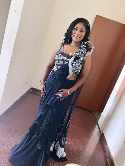 A full-length shot of this unique, modern reception look. The pre-draped ruffle saree is paired with a bold makeup look and glamorous waves.