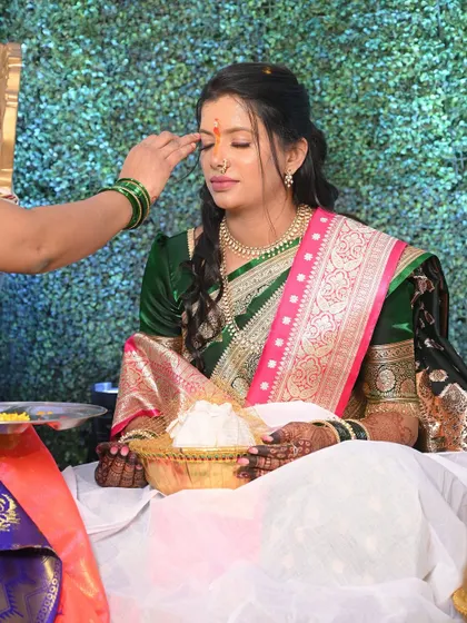 A moment of blessing during the Sakharpuda. The bride's makeup is soft and respectful of the tradition, with a small bindi completing the look.