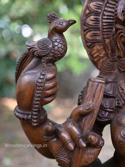 A close-up of the hand of Abhinaya Saraswathi holding a small parrot, a symbol of speech and artistry.
