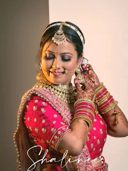 A happy bride adjusts her earring, a beautiful candid portrait from her wedding day.