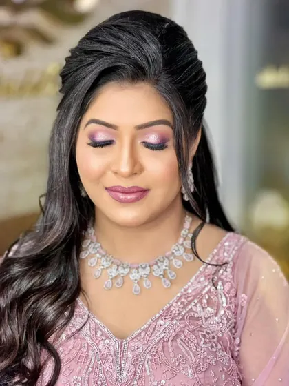 A lovely engagement look featuring a soft pink gown. The bride is wearing a sparkling diamond necklace that perfectly complements her romantic and elegant style.
