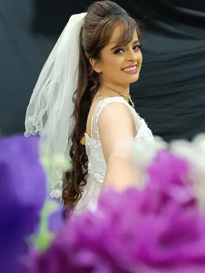 A joyful shot of the Catholic bride, showing how the makeup looks natural and radiant when she smiles. The high ponytail hairstyle is both elegant and modern.
