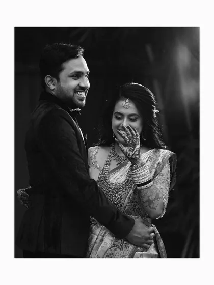 A beautiful black and white portrait of the couple sharing a shy, happy smile during their reception.