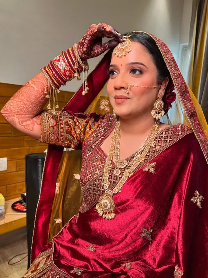 A candid shot of my bride adjusting her dupatta, looking regal in her red velvet lehenga.