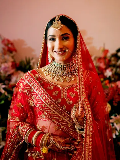 A smiling bride in her red lehenga, a classic portrait that radiates happiness.