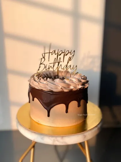 A simple and elegant chocolate drip cake, ready for a birthday celebration. The piped border and glossy ganache make it look as good as it tastes.