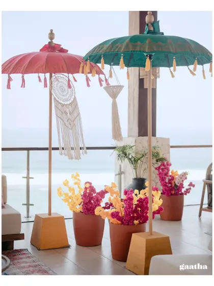 Colorful Balinese umbrellas and bright floral arrangements in terracotta pots create a festive and welcoming entrance for guests.