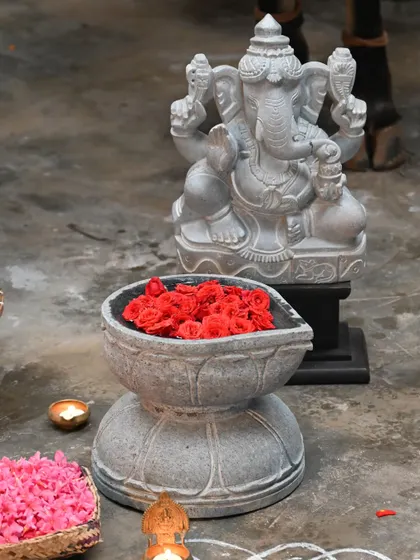 A stone Ganesha and a traditional urli filled with flowers create a beautiful arrangement for the Sankranti festival.
