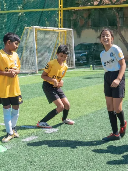 Players sharing a laugh during a game at our Annual Day. We believe a positive and joyful environment is essential for learning.