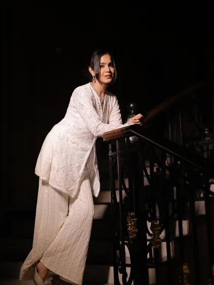 A clear, full-length shot of the white co-ord set on the stairs, showing its classic and elegant design.