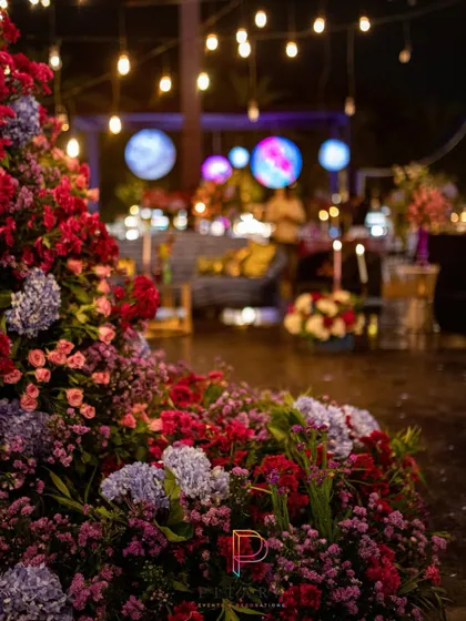 A beautiful chaos of florals in the foreground, with the cosmic-themed bar and hanging planets visible in the background. This shot captures the layers of color and light that made the event so dynamic.
