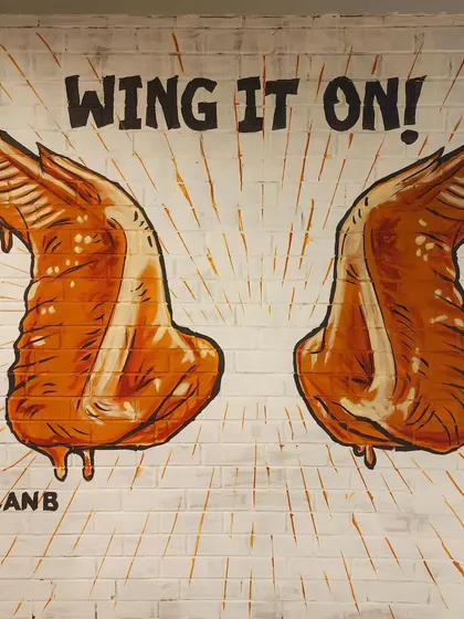 The "Wing It On!" mural, featuring two perfectly sauced chicken wings ready for a selfie.