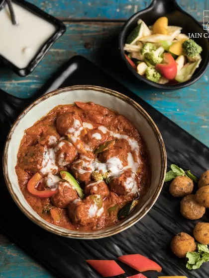 Pure flavours, divine taste. Our vegetable kofta curry, served with fried potato balls on the side, is a delightful dish crafted to perfection.