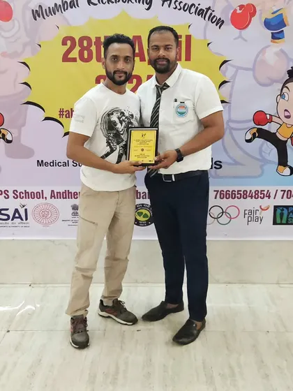 It's an honor to be recognized for our contribution to the sport. Here I am receiving an award at the Mumbai Kickboxing Association event, which reflects our gym's commitment to quality coaching.