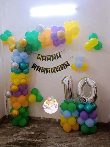A colorful balloon arch with number '10' foils for a birthday party at home.