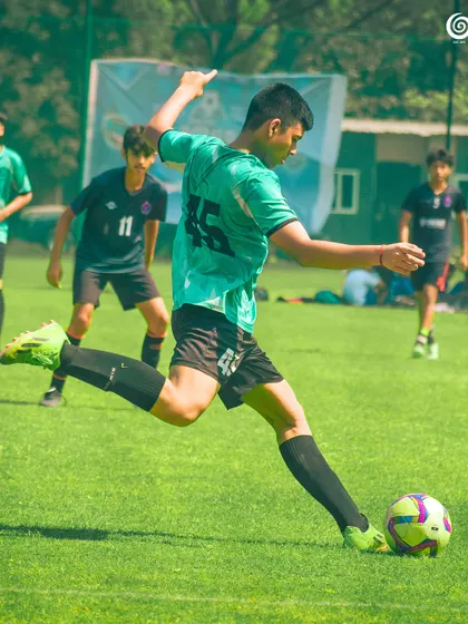 A powerful shot from a U-15 player during a competitive match.