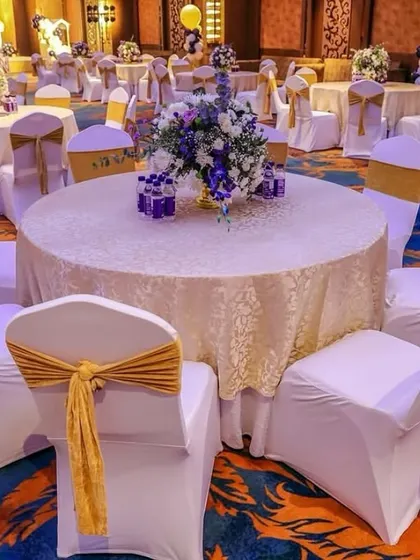 A wide view of the guest seating area, showing the coordinated table settings and chair decorations that carry the royal theme throughout the entire venue.