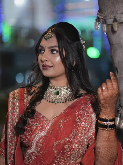 Amrutha's side profile, showcasing her reception hairstyle and makeup. The soft curls and defined makeup create a look that is both modern and timeless.