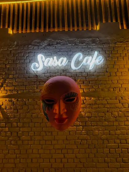 Our signature Sasa Cafe neon sign and mask wall art, a popular backdrop for photos.