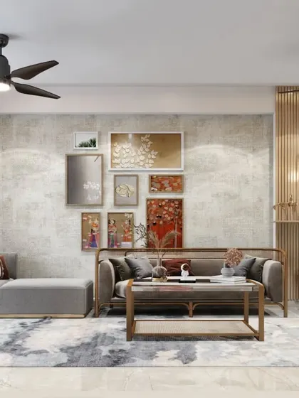 A gallery wall arranged over a modern sofa against a concrete-finish accent wall. The warm, earthy tones of the art complement the room's neutral and industrial-chic aesthetic.