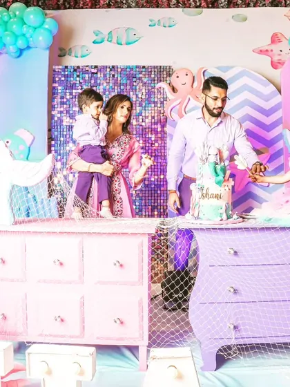 The birthday girl and her family at the cake-cutting ceremony, surrounded by the enchanting mermaid decor, including custom-painted furniture and themed props.