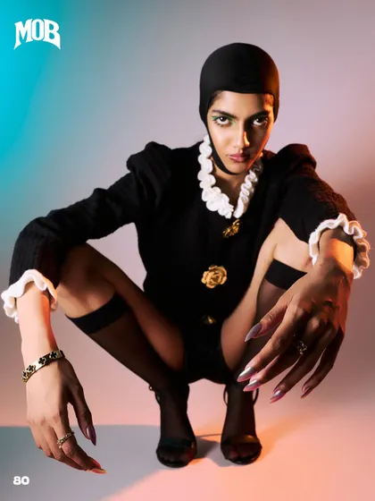 A low, wide-angle pose for MOB Journal, emphasizing the hands and the confrontational gaze of the model.
