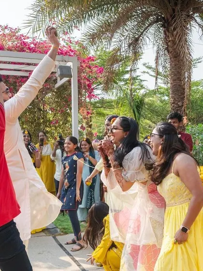 The groom makes a grand entrance at the Haldi ceremony, dancing with friends and family in a joyous celebration.