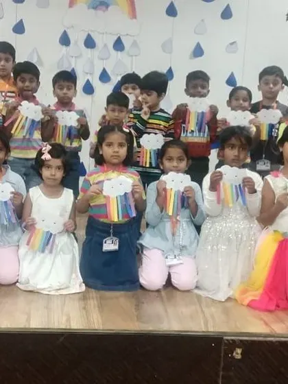 Teachers join their students for a photo, celebrating the success of Rainbow Day and the beautiful art created.