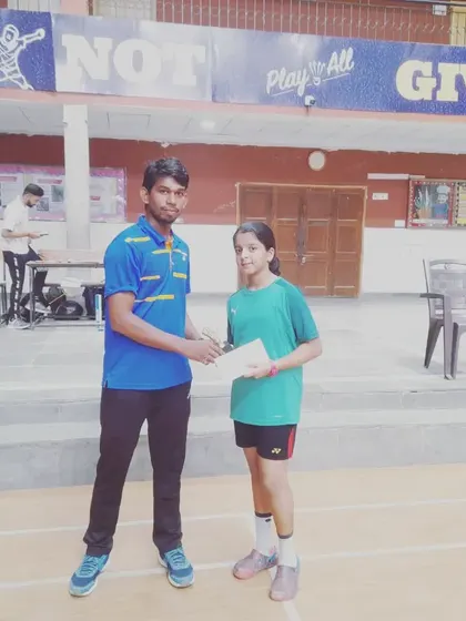 This young girl is a winner at the junior badminton championship, a result of her consistent practice.