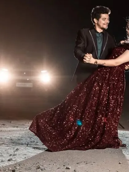 A cinematic shot of the couple dancing in the night. The flowing skirt of the maroon sequin gown adds movement and elegance to this romantic pre-wedding photo.