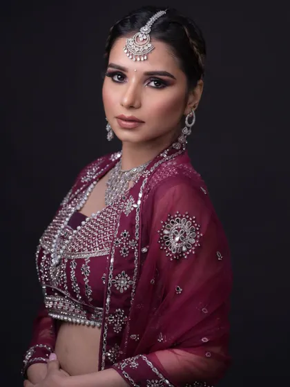 A glamorous reception look with a deep purple lehenga and diamond jewelry. The smokey eye adds drama.