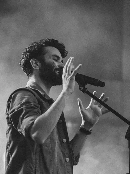 Hands in the air, feeling the music. This black and white shot captures the energy and emotion of a live show.