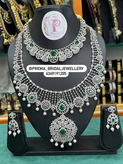 A beautiful AD and emerald set with a delicate, web-like design.