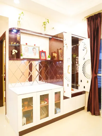 This elegant unit combines a crockery display with a pooja space, featuring CNC-cut doors and mirrored back panels. The design is a perfect blend of modern functionality and traditional aesthetics.