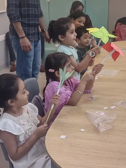 Students hold up the pinwheels they made. This simple craft is a great way to learn about wind energy and aerodynamics.